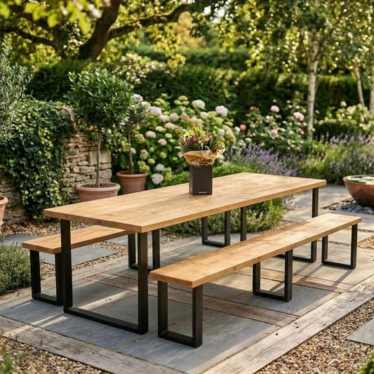 Wooden outdoor dining table with benches in a garden setting